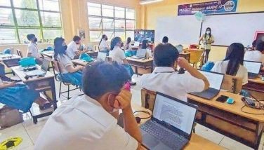 Students use laptops as Para&Atilde;&plusmn;aque National High School turns to &acirc;��hylearn learning,&acirc;�� a type of hybrid learning system, during in-person classes on Feb. 14, 2022.